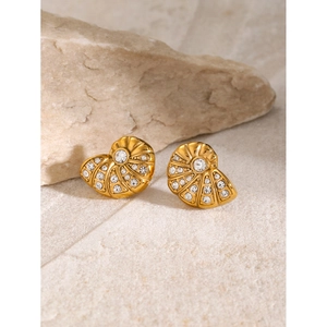 Detailed close-up of shell-shaped 18K gold earrings with sparkling white crystals on stone