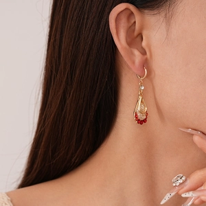 Detailed macro view of vintage gold teardrop earrings with red and white zircons