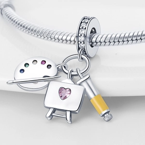 Detailed close-up of silver artist palette, easel, and paint tube charms on a bracelet