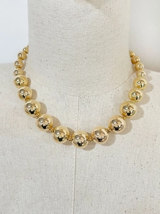 Detailed view of 18K gold-plated beaded necklace on a linen mannequin stand