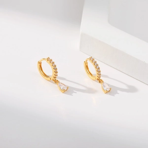 Detailed close-up of 18K gold-plated hoop earrings with red pear-cut zircon pendants