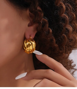 Close-up of golden twist woven earring showing a stylish irregular texture on model