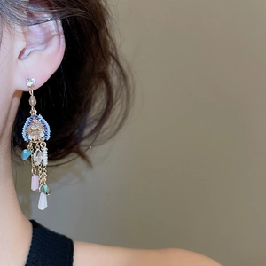 Gros plan de boucles d'oreilles à pompons avec cristaux et perles au look vintage