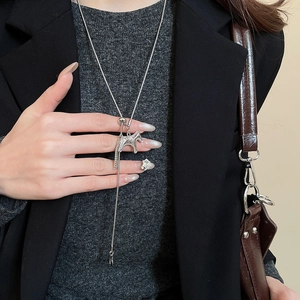 Detailed view of silver horse pendant necklace with fine engraving on black blazer
