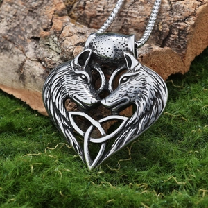 Vintage stainless steel double wolf head heart necklace with Celtic knot on moss background