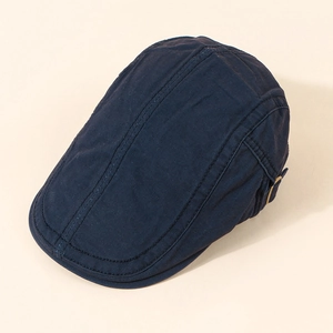 Detail of navy blue cotton flat cap showing bronze metal buckle and stitching