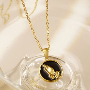 Retro stainless steel necklace with gold prayer hands embossed on a black round pendant