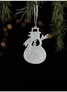 Glittery white snowman ornament hanging from green pine branches for Christmas decor