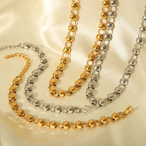 Detailed view of luxury gold and silver bead link necklaces on soft beige silk background