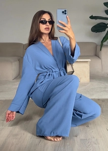 Detailed view of blue crepe fabric texture on long sleeve tie-up top and trousers set