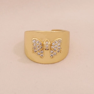 Macro detail of polished gold butterfly ring featuring micro-pave cubic zirconia settings