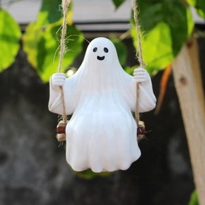 Close-up of a white ghost figurine on a wooden swing with hemp rope for garden decor