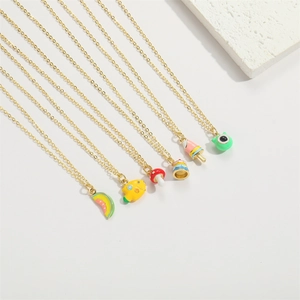 Detail shot of colorful enamel mushroom and cake pendants on a gold chain necklace