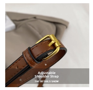 Detail of brown leather adjustable shoulder strap with premium golden metal buckle