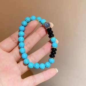 Macro detail of turquoise beads with black onyx and gold spacers on beaded bracelet