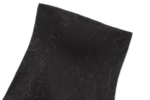 Detailed macro view of black textured fabric with metallic silver cracked pattern