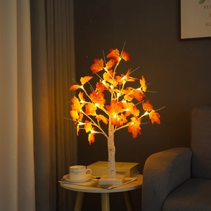Close-up of lit birch tree lamp with realistic orange maple leaves and warm white LEDs