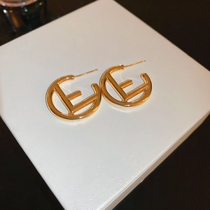 Elegant gold round earrings featuring a hollow letter E design on white gift box