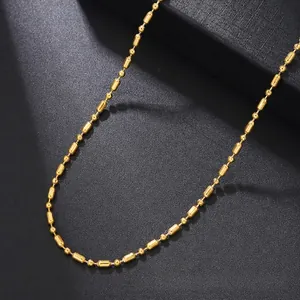 Detailed close-up of a gold-plated stainless steel barrel bead chain on a black display