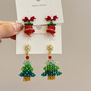 Detail of beaded Christmas tree and red bell earrings with pearls and bows