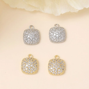 Macro shot of gold and silver square pendants with micro-pave cubic zirconia crystals