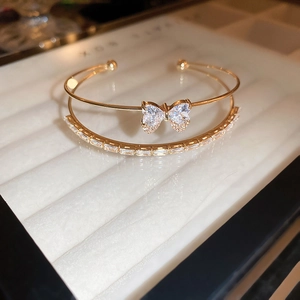 Macro detail of gold double-row open cuff with zircon bow and rectangular crystals