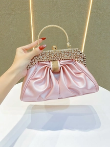 Detail of pink pearlescent evening bag with luxury rhinestone trim and golden handle