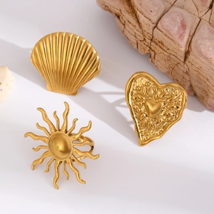 Detailed view of textured golden shell, sun, and heart shaped stainless steel rings