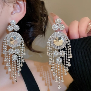 Detail of luxury silver fringe earrings with layered rhinestones and geometric design