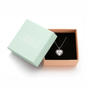 Detail of teal and pink jewelry box with engraved heart necklace for Mother's Day