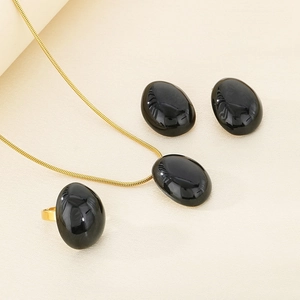 Detail shot of the gold jewelry set with polished black oval enamel stones
