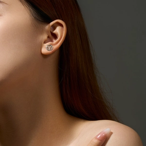 Close-up of 925 sterling silver clover stud earring with micro-inlay on model's ear