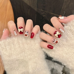 Christmas press-on nails with red bows, reindeer designs, and festive 3D winter art