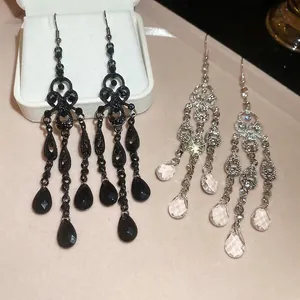 Vintage palace style teardrop crystal hollow earrings with tassels on beige leather texture