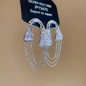 Boucles d'oreilles argentées avec zircons géométriques et longs pompons de chaînes