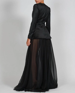 Detail eines schwarzen Satin-Oberteils und langen Chiffon-Maxirocks mit hohem Beinschlitz