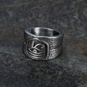 Polished stainless steel Eye of Horus ring with hammered texture on stone background