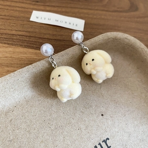 Detail of flocked rabbit pendant with round pearl and silver post on display tray