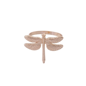 Macro shot of rose gold dragonfly napkin ring with colorful oil drip detailing