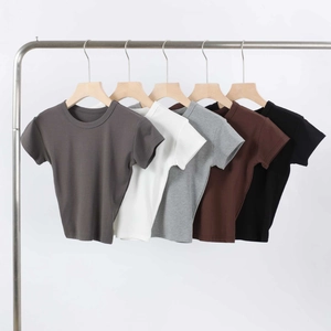 Detail view of basic crew neck T-shirts in five colors on a studio garment rack