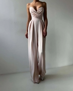 Detail of elegant satin jumpsuit showing thin straps and V-neckline in champagne pink