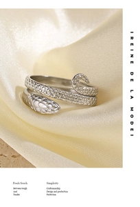 Detailed macro view of silver snake ring with scales on a luxury silk background