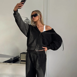 Détail du pantalon noir oversize à cordon de serrage et de l'ensemble à capuche