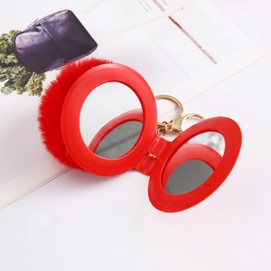 Detail of red faux rabbit fur ball folding makeup mirror keychain with gold hardware