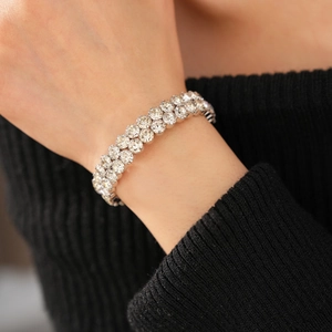 Gros plan d'un bracelet double rangée de diamants au poignet avec des oxydes de zirconium