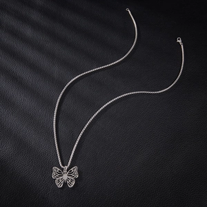 Collier avec pendentif papillon en acier inoxydable sur fond de cuir noir texturé