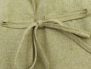 Detailed close-up of olive green linen trousers featuring a tied waist belt and stitching