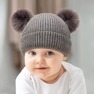 Infant winter knit hat with dual dark grey faux fur pom-poms and warm ribbed cuffs