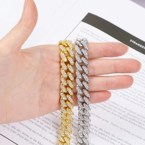 Detail of gold and silver iced out Cuban bracelets with zircon stones on a magazine page