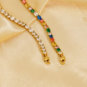 Dettaglio macro di bracciali tennis con zirconi colorati su lussuoso sfondo di seta dorata